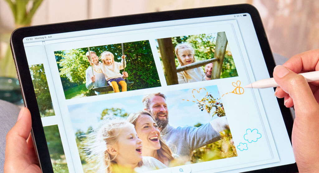 Person gestaltet auf einem Tablet eine Fotoseite mit Familienfotos und bunten Zeichnungen